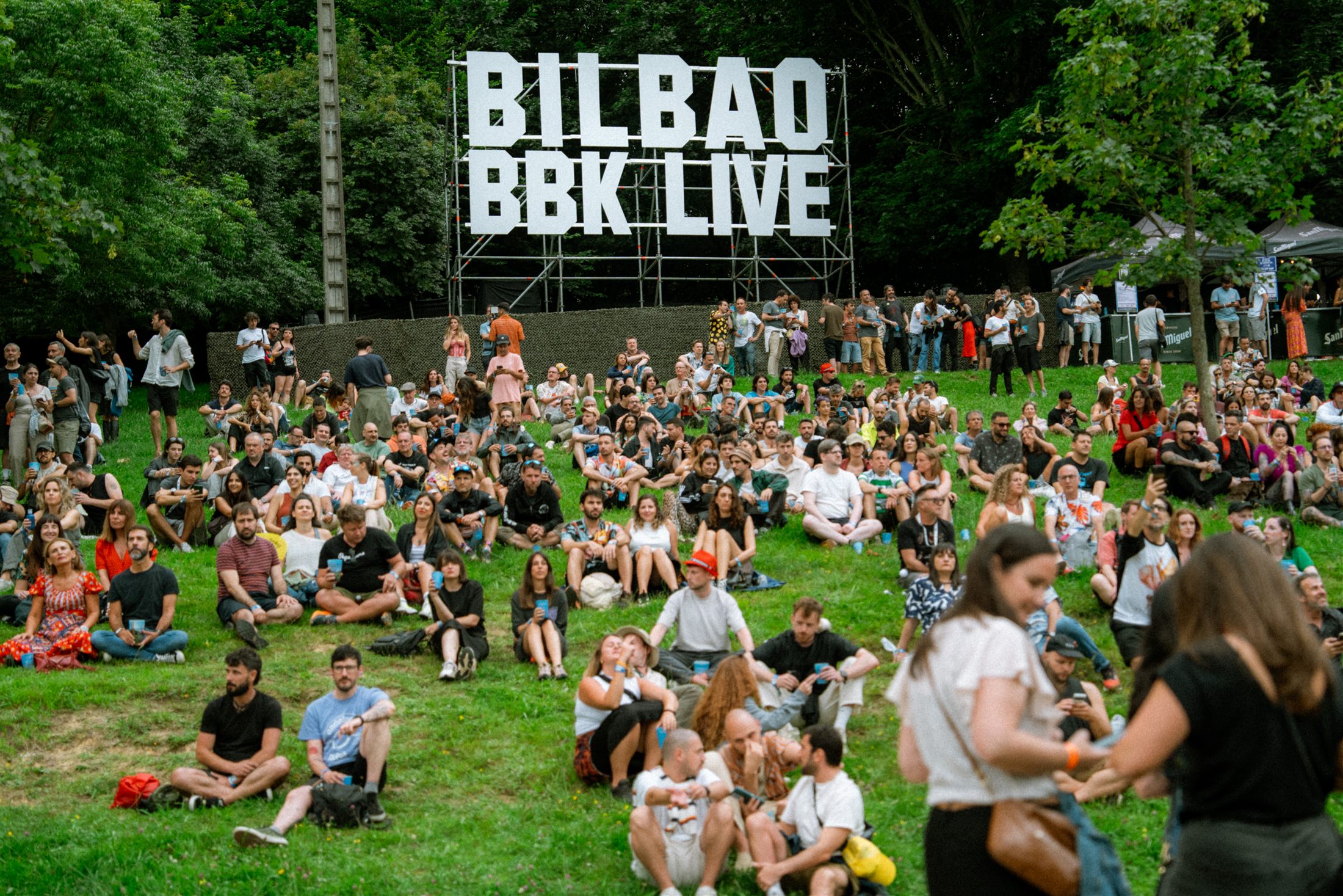 Asistentes descansando en el césped frente al escenario de Bilbao BBK Live 2024 - fotografía de Noland Live