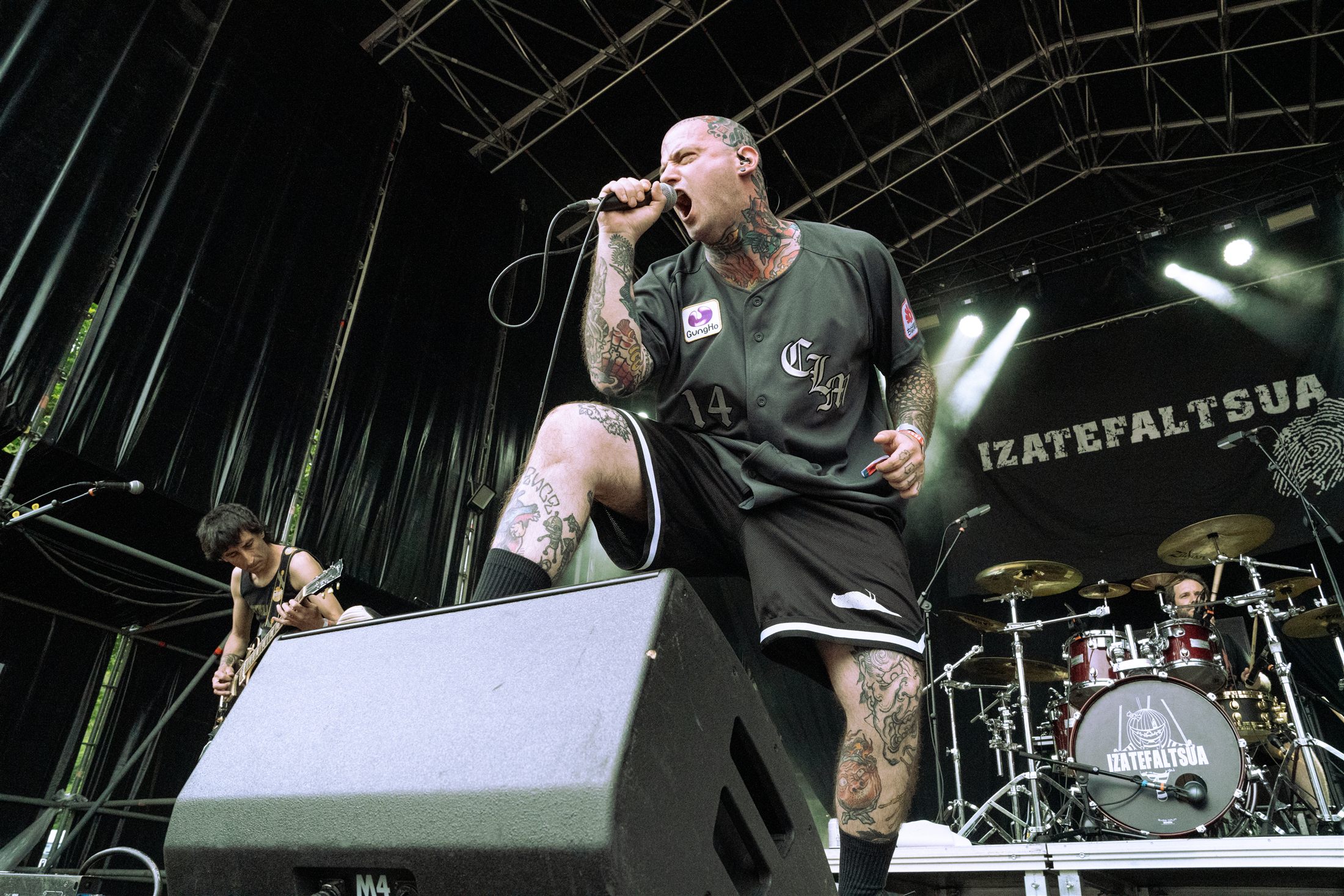 Cantante tatuado con un pie sobre el monitor de escenario